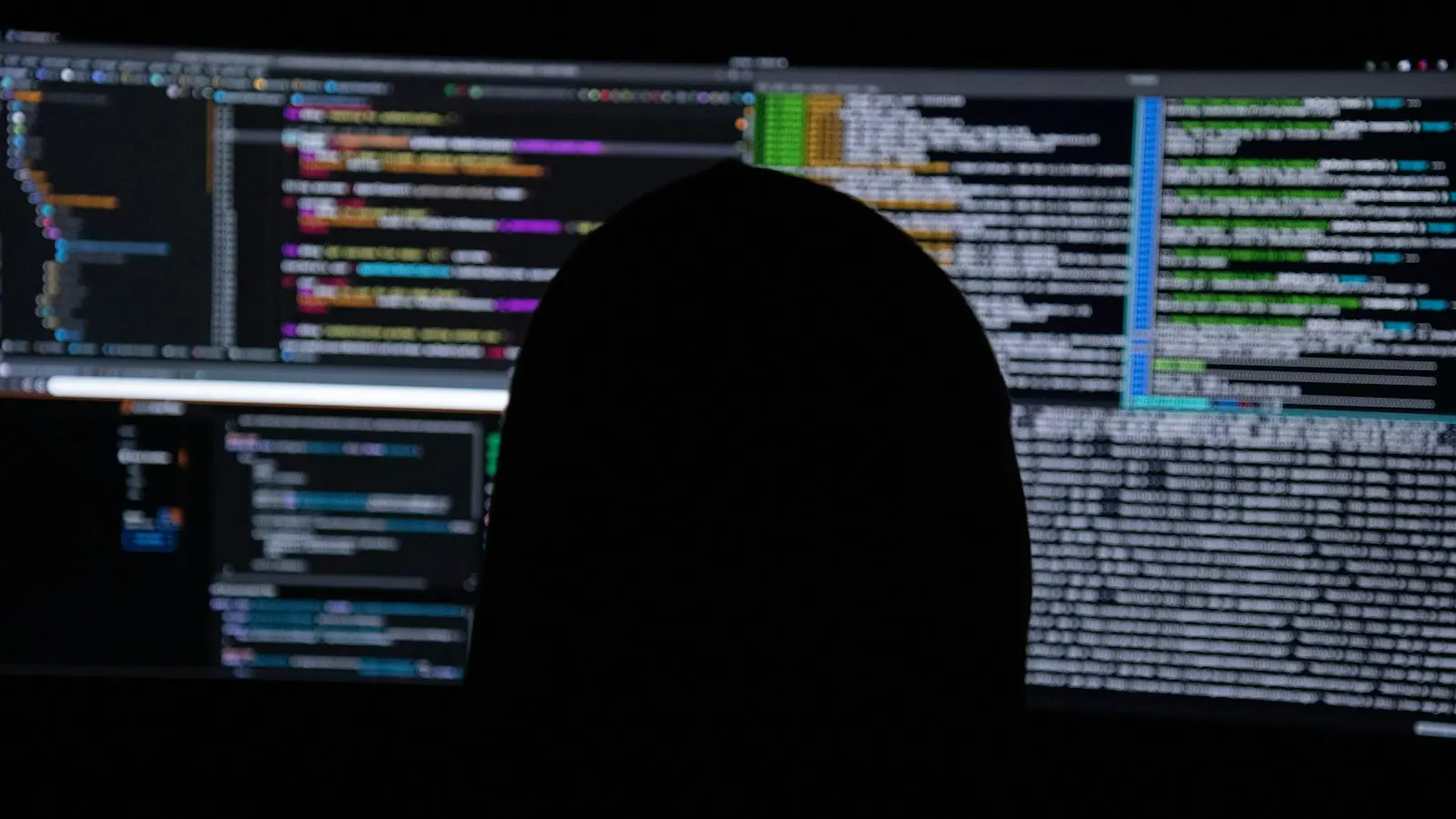 Security tester in front of screens full of code during a penetration test